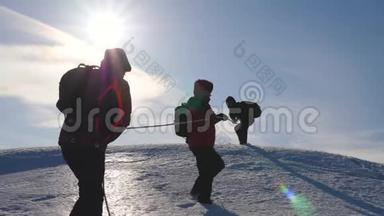 三个登山队员在雪山上爬绳.. 旅游者一起工作，集体摇身一变，克服困难